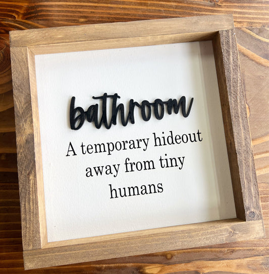 Bathroom a temporary hideout away from tiny humans sign